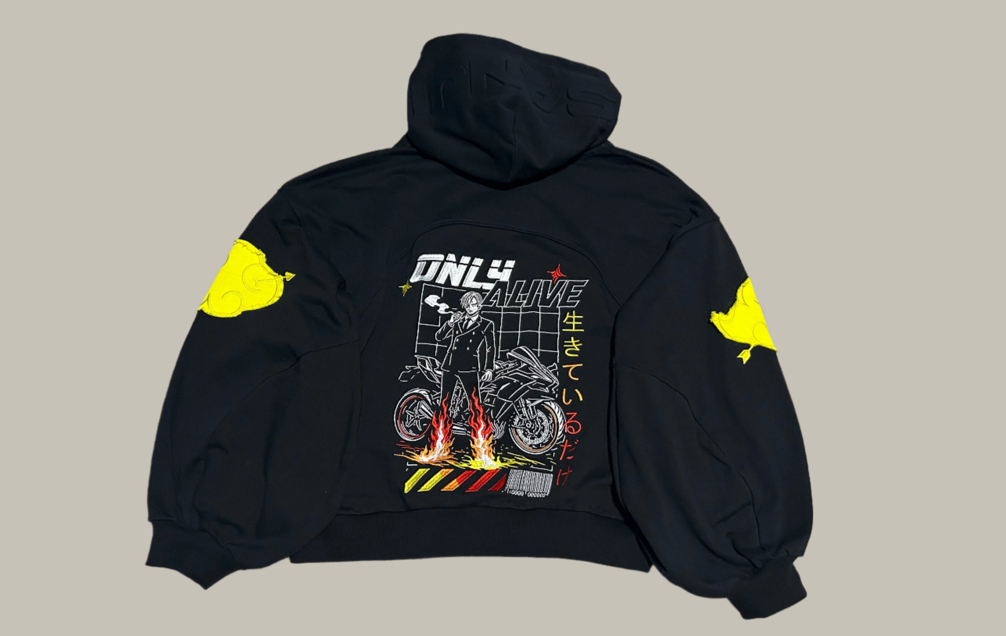 Black hoodie with a graphic design on the back, featuring a motorcycle and text, on a gray surface.